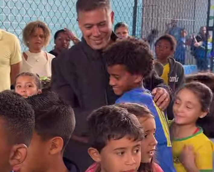 Com ajudante especial, prefeito entrega uniformes e prova a merenda dos alunos