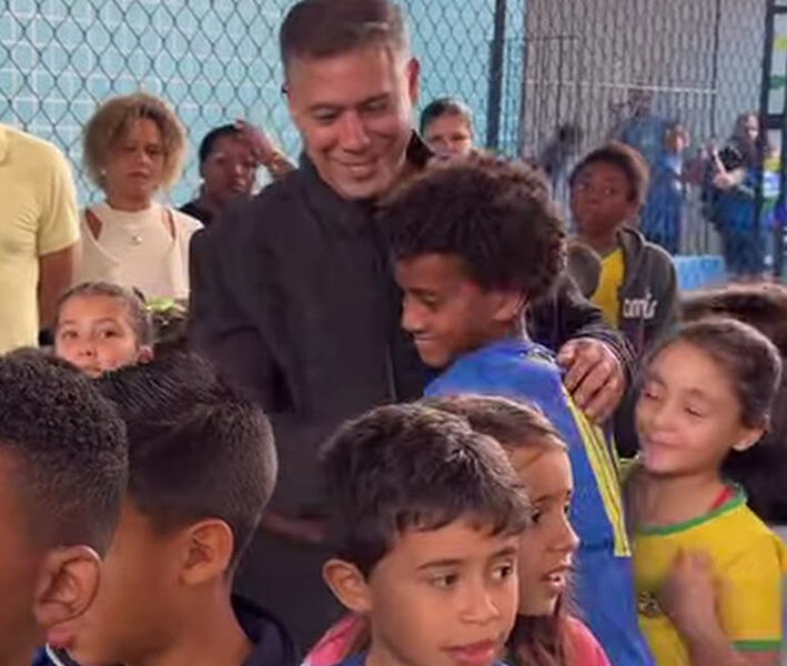 Com ajudante especial, prefeito entrega uniformes e prova a merenda dos alunos